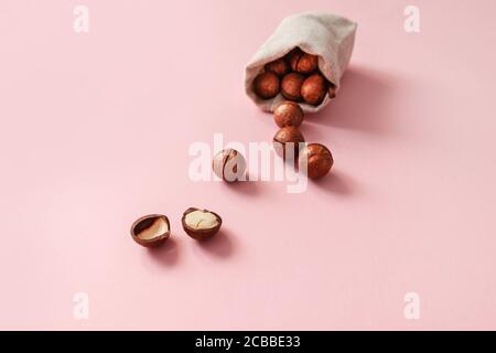 Macadamia nuts in bag on a pink background design for poster, article or banner Stock Photo