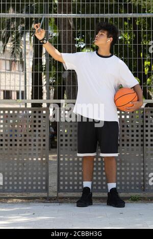 Afro boy with a basketball taking a selfie Stock Photo