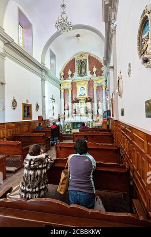 Pilgrims pray in the chapel where Saint Toribio Romo was the parish priest in Santa Ana de Guadalupe, Jalisco State, Mexico. Father Toribio was a Mexican Catholic priest and martyr who was killed during the anti-clerical persecutions of the Cristero War.