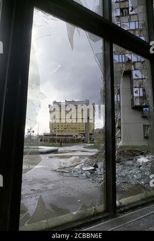 12th April 1994 During the Siege of Sarajevo: the almost undamaged east-facing side of the Holiday Inn Hotel, viewed through a broken window of the Unis Towers complex. Stock Photo