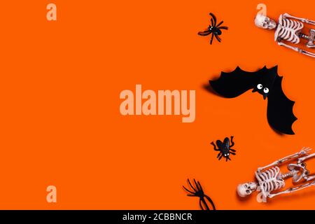 Halloween decoration picture - orange background with spider, bat, skeletons. Flat lay with a place for your text. Stock Photo