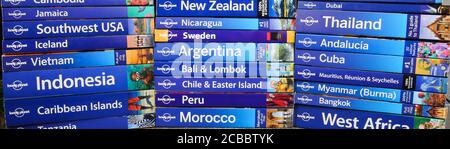 Viersen, Germany - July 9. 2020: View on stack of lonely planet trevel guide books from all over the world (focus on center) Stock Photo