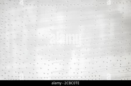 Old silver metal surface of the aircraft fuselage with rivets.  Stock Photo