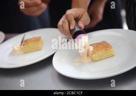 Baker decorating the delicious pastry cake Stock Photo