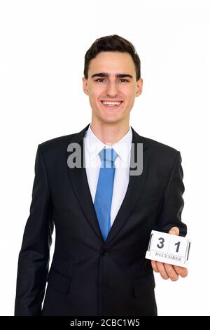 Studio shot of young handsome Caucasian businessman holding 31 December calendar isolated against white background Stock Photo