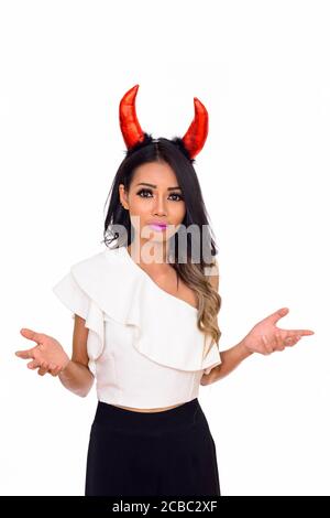 Studio shot of young beautiful Asian woman wearing horns isolated against white background Stock Photo
