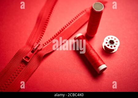 threads and zipper on a red minimalistic background Stock Photo