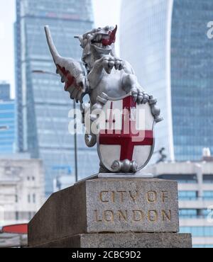 Symbolic Griffin or Gryphon dragon statue marking the entrance to the City of London, at south end of London Bridge with the City skyline behind it. Stock Photo