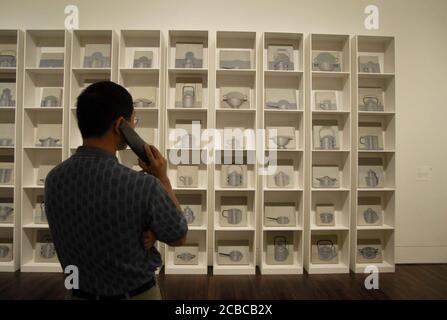 Austin, Texas USA,  April 2006: Visitor uses a listening device for information about art on display during grand opening festivities at the Blanton Museum of Art at the University of Texas. The Blanton took over a decade in planning and construction and attracted large crowds during its first weekend. ©Bob Daemmrich Stock Photo