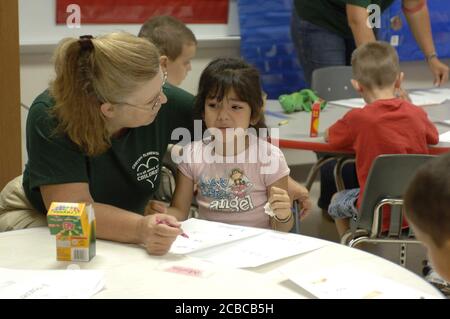 Mabank, Texas USA, August 17, 2006: During the first week of classes at Mabank Central Elementary School, a kindergarten teacher comforts a crying student during art time. ©Bob Daemmrich Stock Photo