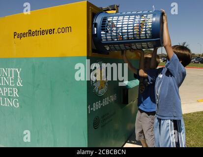 4th grade boys deposit paper into recycle bin at elementary school, Round Rock, Texas. ©© Bob Daemmrich Stock Photo