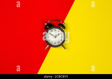 isolated black clock on a two-tone background, top view Stock Photo