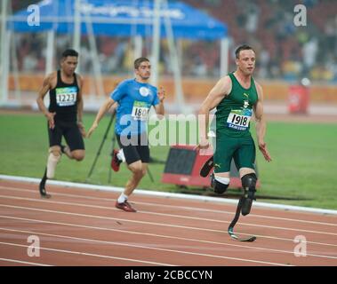 Beijing, China, September 8, 2008. Second day of athletics at the Bird's Nest Olympic stadium during the Paralympics. Oscar Pistorius (right) of South Africa leads the pack in his 100 meter heat. ©Bob Daemmrich Stock Photo