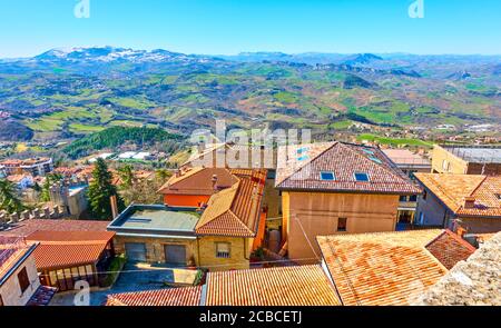 Tiled roofs in San Marino and landscape with mounains in the background Stock Photo
