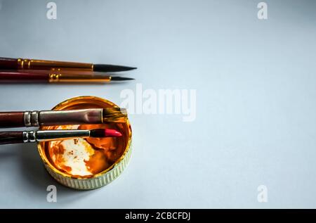 Yellow gouache cap and four brushes on a light background with space for text Stock Photo