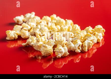 Sweet tasty popcorn on red background. Stock Photo