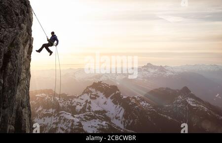 Epic Adventurous Extreme Sport Composite of Rock Climbing Man Rappelling Stock Photo