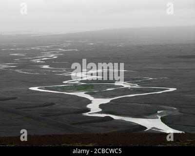 Black glacier flood plain called sandur and meandering river flowing into the sea, Skaftafell National Park, Iceland Stock Photo
