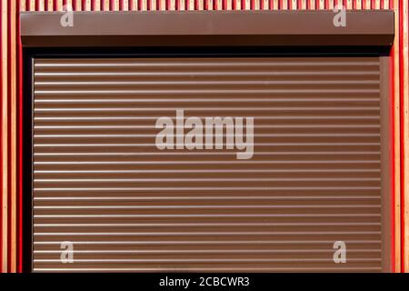 Metal rollers shutters horizontal brown color, closed shutters close-up. Stock Photo