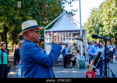 Music in Rome, male street jazz musician playing trumpet at a chocolate fair, Villa Borghese public park, Rome, Italy Stock Photo