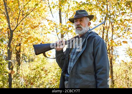 Caucasian older hunter stand in autumn 