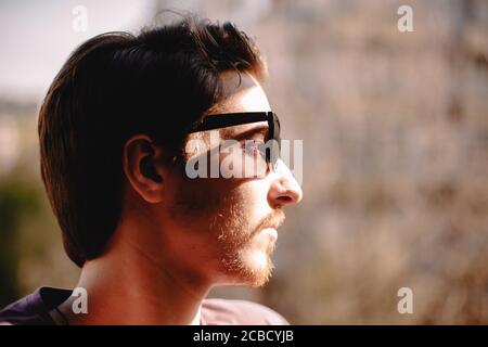 Close up portrait of young depressed man wearing sunglasses Stock Photo