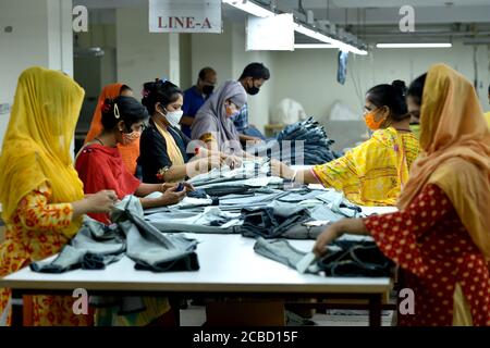 Dhaka. 12th Aug, 2020. People work at a garment factory in Dhaka, Bangladesh, on Aug. 12, 2020. Bangladesh's July export income was over 44 percent higher than that in June, meaning the country's export sector is limping back to normalcy after suffering serious blows owing to COVID-19 impacts. Of the total earnings, the Export Promotion Bureau (EPB) data showed the country's income from ready-made garment items, including knitwear and woven, stood at 3.24 billion U.S. dollars. Credit: Xinhua/Alamy Live News Stock Photo