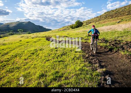 A woman climbing the trail on Lewis Butte outside Winthrop, Washington on a sunny afternoon in May. Stock Photo