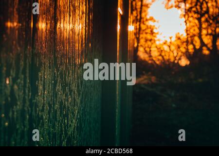 A Bright Orange Sunrise Casting a Reflection off of a Frost Covered Fence Stock Photo