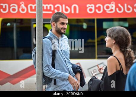 Young Georgian man and woman in a bus stop of Didube station, Tbilisi, Republic of Georgia Stock Photo