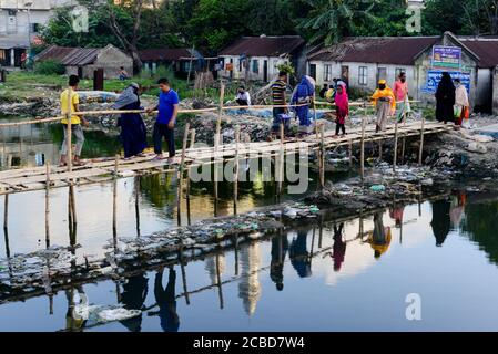 Dhaka, Bangladesh. 12th Aug, 2020. People crossing a river polluted with industrial garbage on a bamboo bridge.Dhaka is going back to its normal life after some months of the ongoing pandemic. Credit: SOPA Images Limited/Alamy Live News Stock Photo