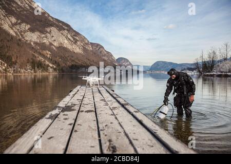 Drone Crash - Diver Standing Next to a Retrieved Drone Stock Photo
