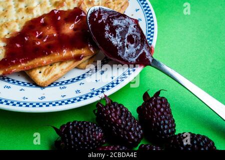Fresh jam with cookies on a plate on a green surface Stock Photo