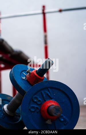 Old blue gym weights on the floor in a gym Stock Photo