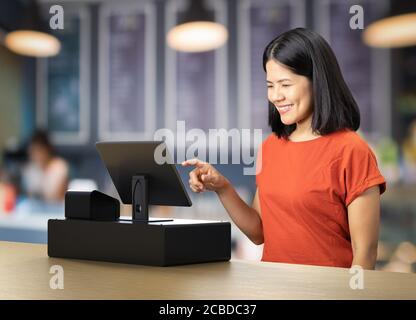 Asian woman wear red t-shirt with cashier desk Stock Photo