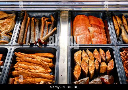 Different types of smoked fish for sale in a stand. Stock Photo