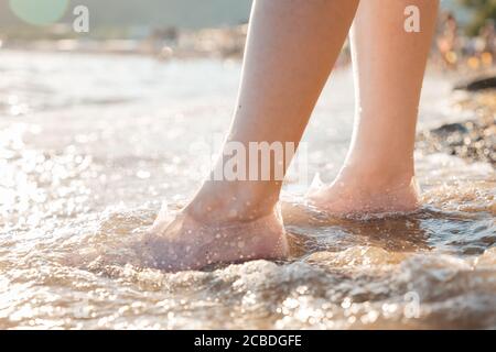 A woman stands in rubber shoes for swimming on the beach. Feet close up. The concept of the protection and health of the feet Stock Photo Alamy