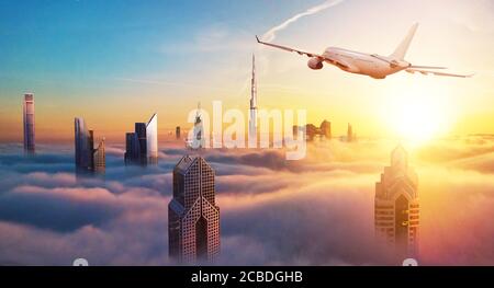 Private jet plane flying above Dubai city in beautiful sunset light. Modern and fastest mode of transportation, business life. Stock Photo