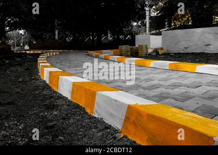 a long view of yellow & white color isolated on walking path in park Stock Photo