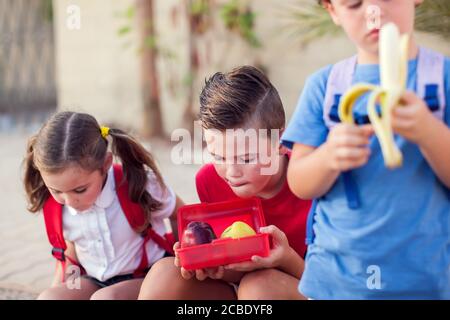 Pupils having a snack outdoor. Children, education and nutrition concept Stock Photo