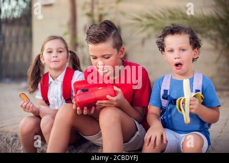 Pupils having a snack outdoor. Children, education and nutrition concept Stock Photo