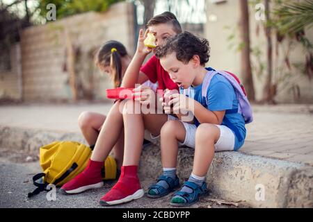 Pupils having a snack outdoor. Children, education and nutrition concept Stock Photo