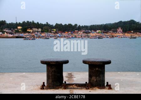 Aerial Panoramic view of tourists taking a dip in the turquoise waters of Lighthouse beach at Kovalam, with green coconut trees and blue waters Stock Photo