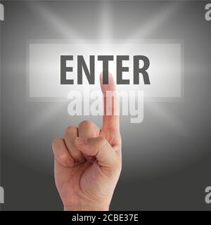 Person's forefinger pushing an enter button on a gray background Stock Photo