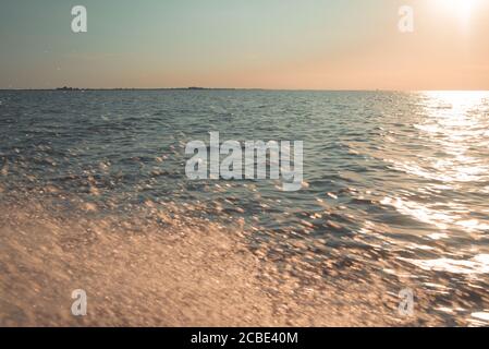 Splashes of water in the sea into the sunset, pastels colors. Stock Photo