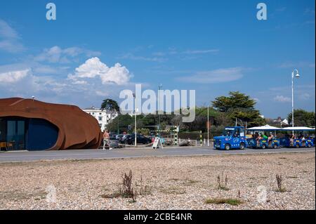 Littlehampton, West Sussex, UK, August 12, 2020. Tourist train with holidaymakers passing the East Beach Cafe. Stock Photo