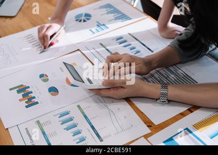 Close up Businessman and partner using calculator and laptop for calaulating finance, tax, accounting, statistics and analytic research concept Stock Photo