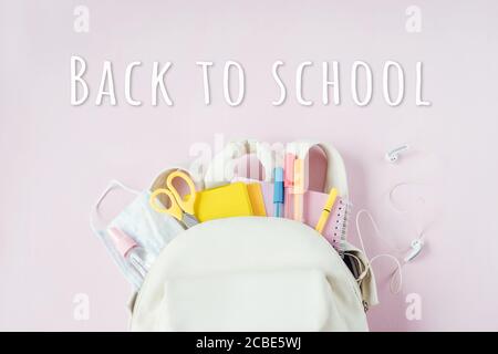 Student school bag with medical mask and hand sanitizer clip on, school reopening, return back to school after covid-19 coronavirus pandemic is over, Stock Photo