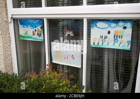 rainbow posters made by children for the nhs placed in windows during covid-19 pandemic lake district cumbria england uk Stock Photo