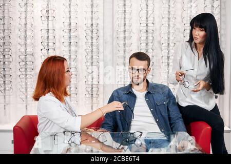 serious bearded pensive thoughtful handsome man choosing eyeglasses, selecting the best ones. close eup photo Stock Photo